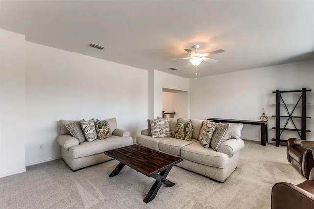a living room with furniture and a ceiling fan