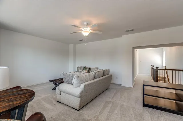 a living room with furniture and a ceiling fan