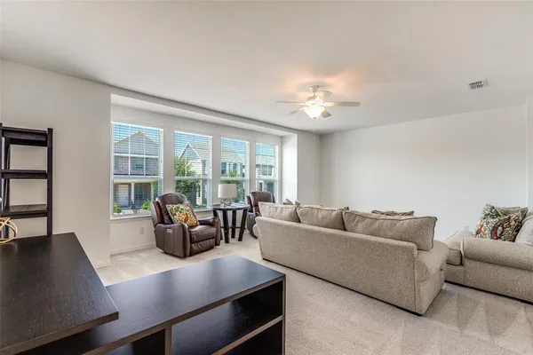 a living room with furniture and large windows