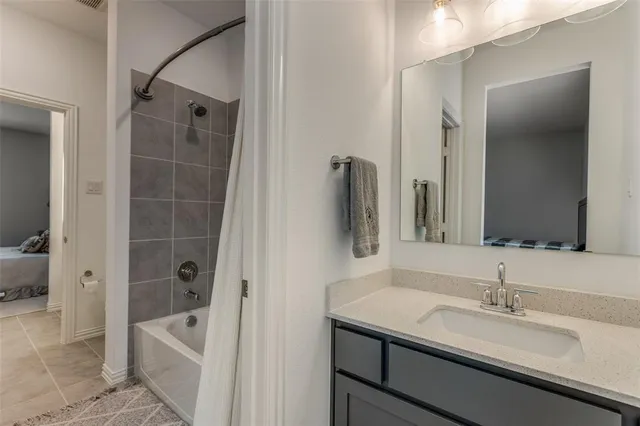 a bathroom with a granite countertop sink a mirror a bathtub and shower