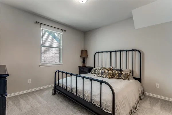 a bed sitting in a bedroom next to a window