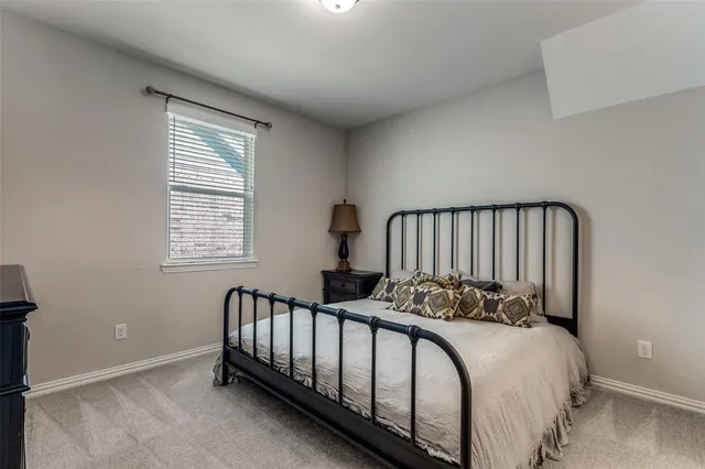 a bed sitting in a bedroom next to a window