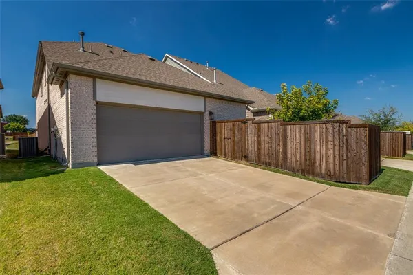 a view of backyard with potted plants and wooden fence