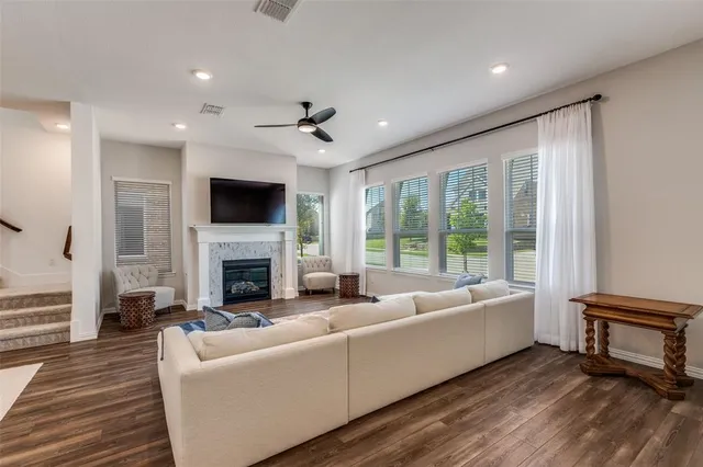 a living room with furniture a fireplace and a flat screen tv
