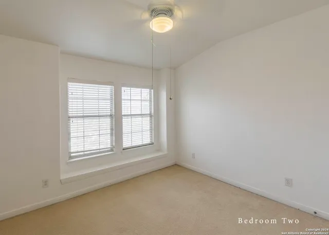 a view of an empty room with a window and closet area