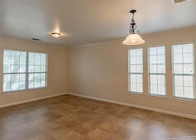 an empty room with windows and chandelier