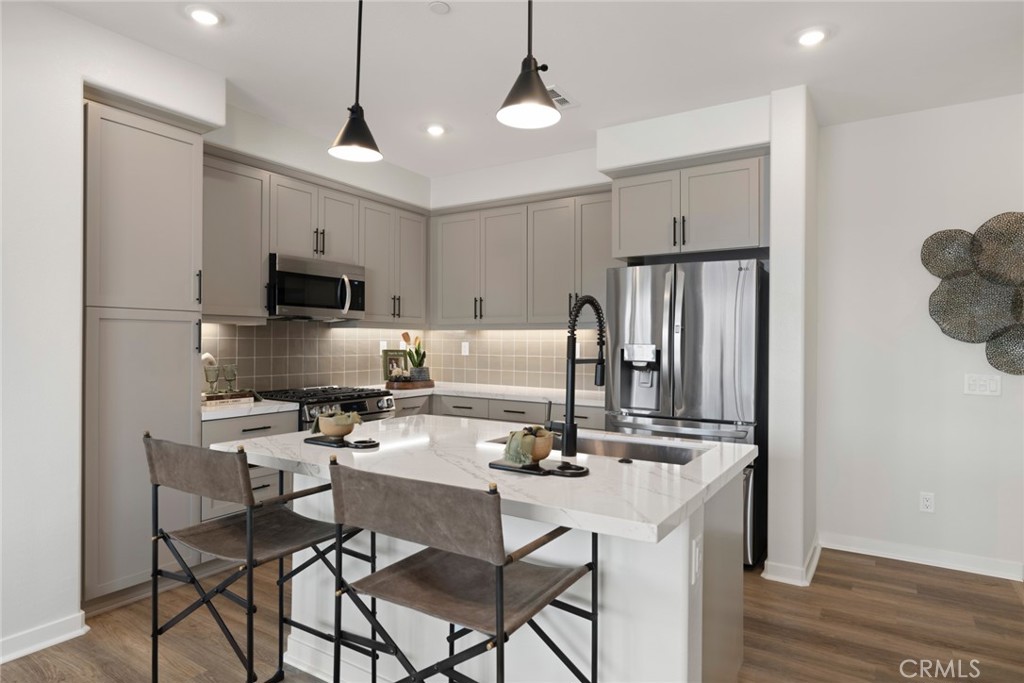 12250 Mirasol Loop, Unit H El Monte, CA 91732 - Photo 8 of 18 a kitchen with a dining table chairs refrigerator and cabinets
