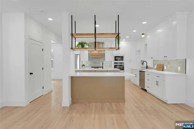 a large white kitchen with a large window
