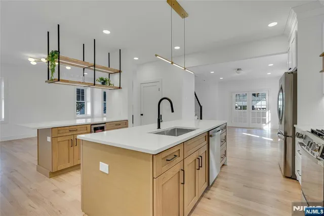 a kitchen with stainless steel appliances granite countertop a sink and a refrigerator