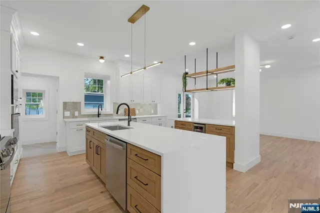 a kitchen with kitchen island a sink appliances and cabinets