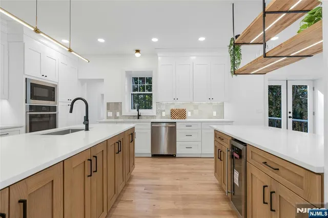 a kitchen with white cabinets a sink and dishwasher