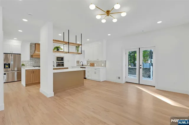 a view of a kitchen with wooden floor and electronic appliances