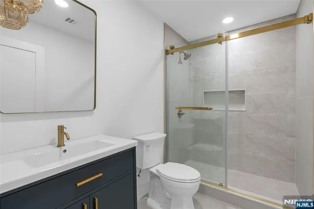a bathroom with a sink toilet a mirror and shower