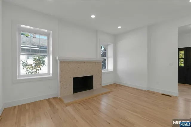an empty room with windows and fireplace