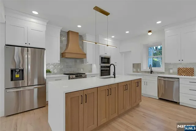 a kitchen with white cabinets and stainless steel appliances