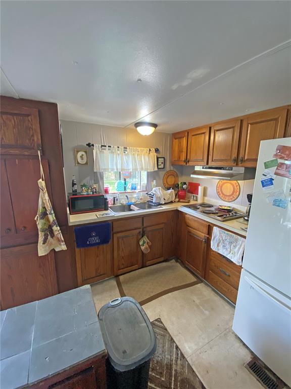 148 Swan Lake Road Melrose, FL 32666 - Photo 12 of 30 a kitchen with a sink a stove cabinets and a dining table