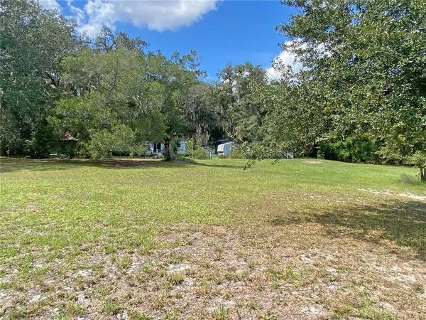 a view of a green field with lots of bushes