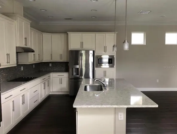 a kitchen with stainless steel appliances granite countertop a sink refrigerator and cabinets