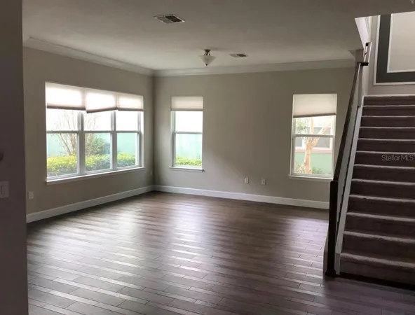 wooden floor in an empty room with wooden floor and windows