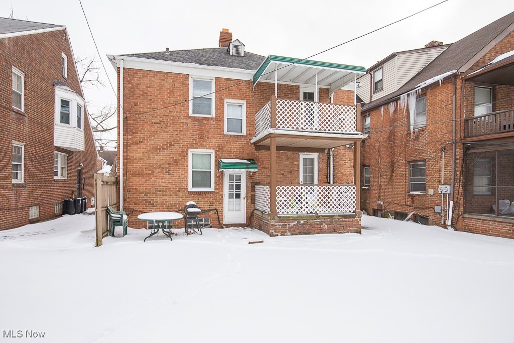 13545 Cedar Road Cleveland, OH 44118 - Photo 39 of 41 Snow covered back of property featuring a chimney, cooling unit, and brick siding