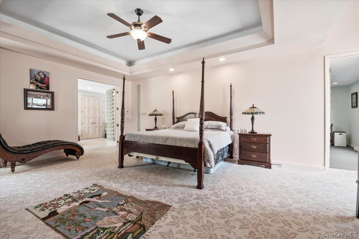 12 Ridge Court Glen Head, NY 11545 - Photo 22 of 46 Bedroom featuring light colored carpet, a raised ceiling, ceiling fan, and recessed lighting