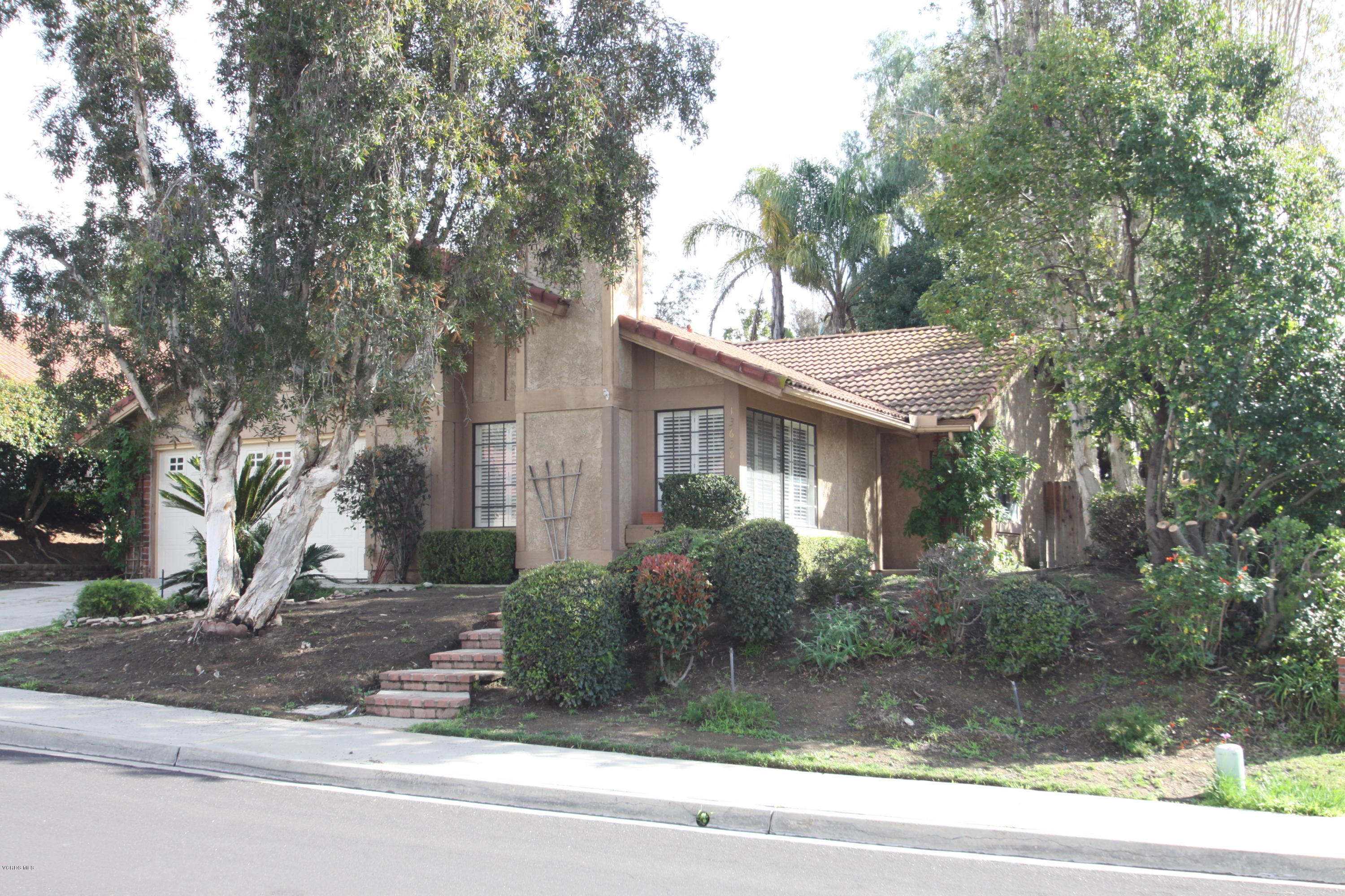 a front view of a house with a yard garage and outdoor seating