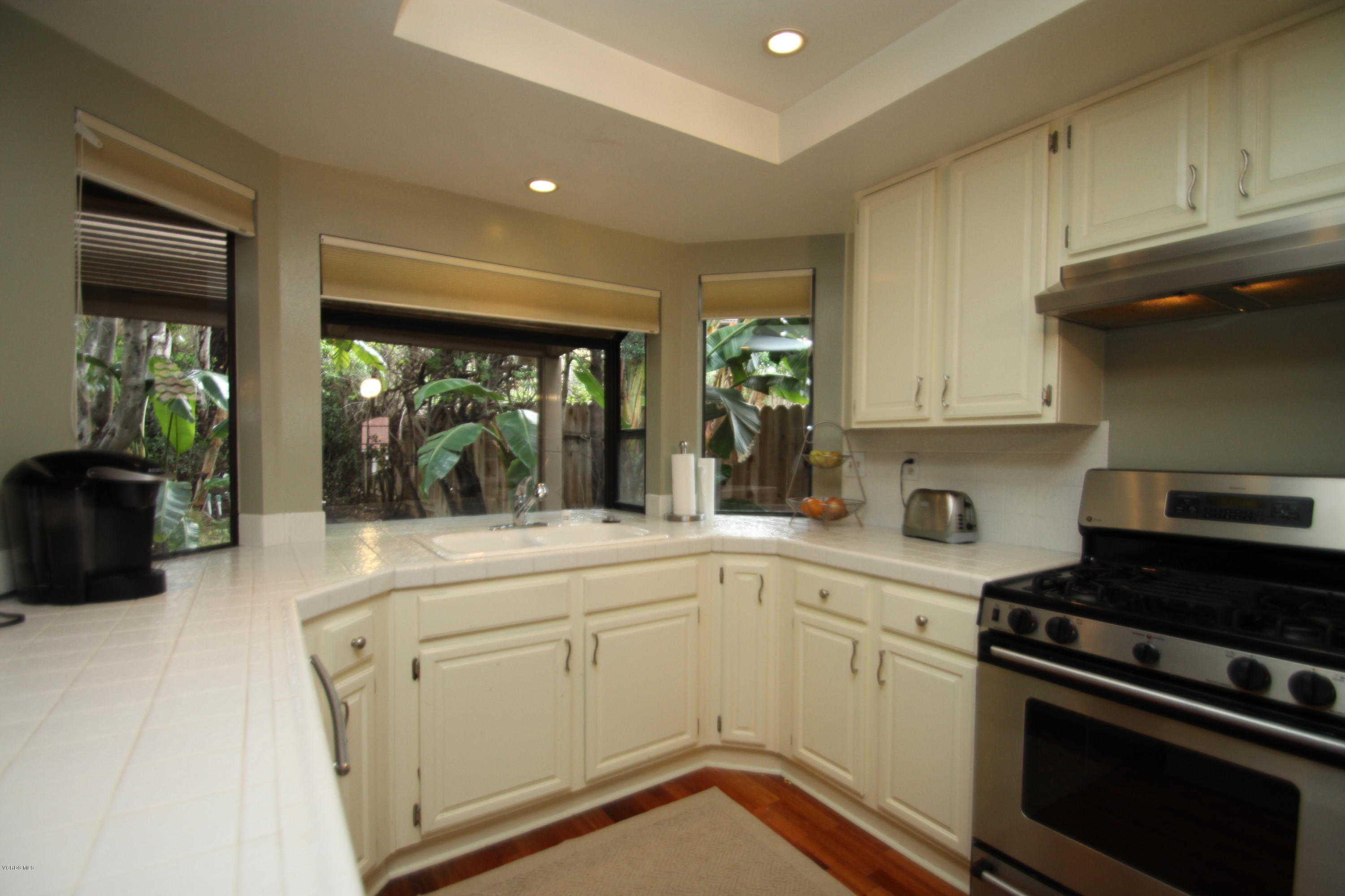13638 Bear Valley Road Moorpark, CA 93021 - Photo 7 of 18 a kitchen with a stove and white cabinets