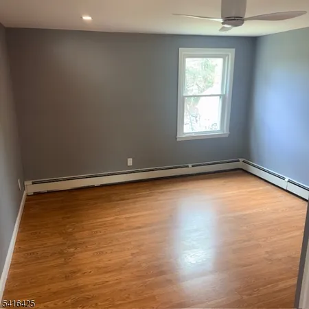 a view of a room with wooden floor and window