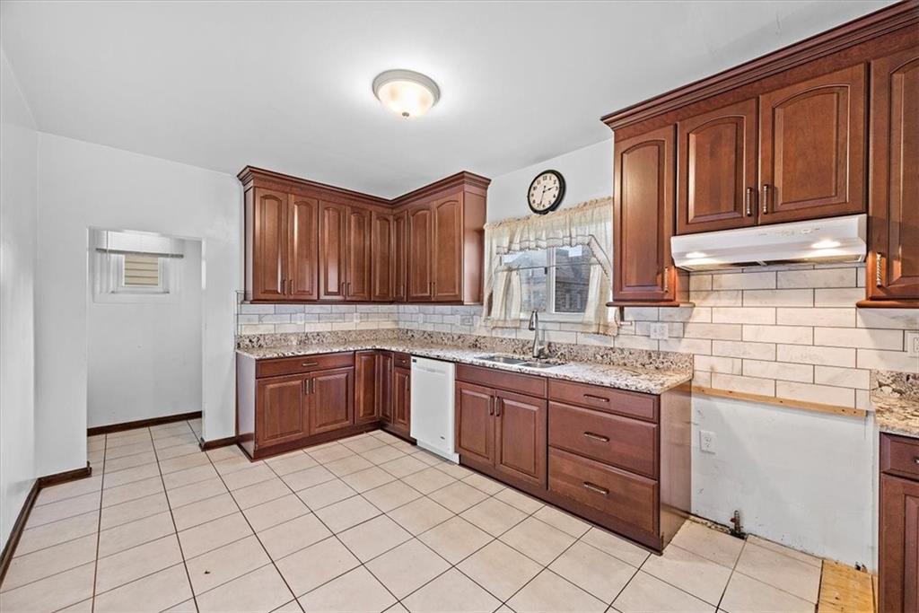 915 1st Street McKees Rocks, PA 15136 - Photo 11 of 25 a kitchen with granite countertop a sink stove and cabinets