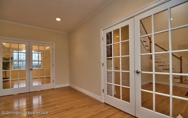 a view of empty room with wooden floor and windows