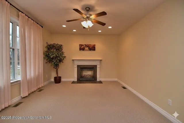 a view of an empty room with a fireplace and a window