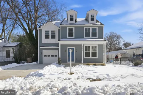 a front view of a house with a yard covered in snow