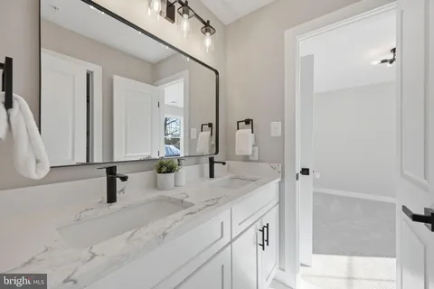a bathroom with double vanity sink and a mirror