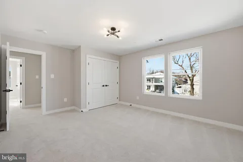 an empty room with windows and closet