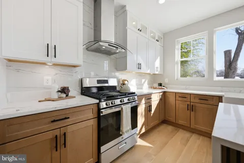 a kitchen with stainless steel appliances granite countertop a sink a stove and cabinets