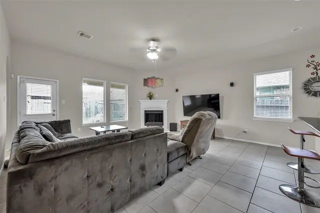 a living room with furniture a fireplace and a flat screen tv