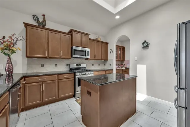 a kitchen with stainless steel appliances granite countertop a stove a sink and a refrigerator