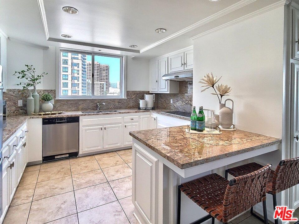 10550 Wilshire Boulevard, Unit 1004 Los Angeles, CA 90024 - Photo 20 of 39 a kitchen with a sink dishwasher a stove top oven a dining table and chairs