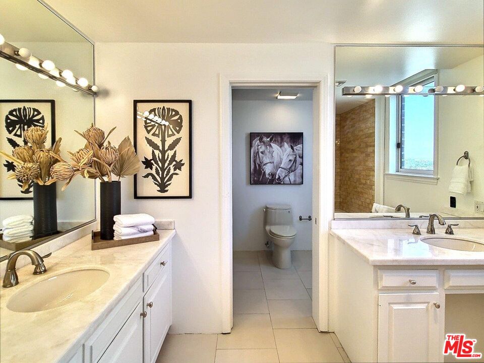 10550 Wilshire Boulevard, Unit 1004 Los Angeles, CA 90024 - Photo 29 of 39 a bathroom with a toilet sink and mirror