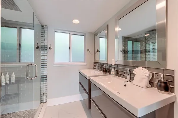 a en suite bathroom with a double vanity sink a mirror and a shower