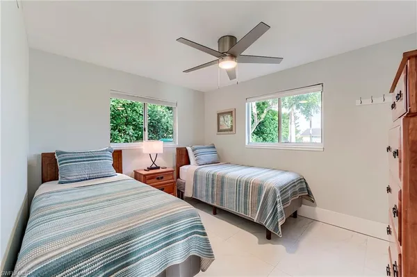 a bedroom with two beds and a chandelier