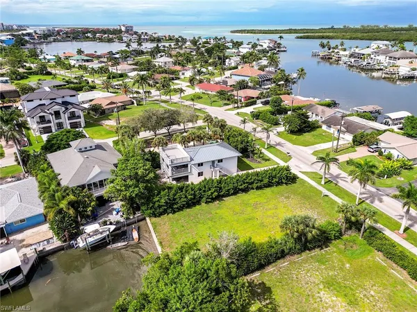 an aerial view of residential houses with outdoor space and lake view