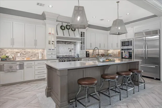 a kitchen with kitchen island granite countertop a sink cabinets and stainless steel appliances