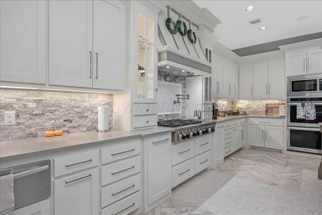 a kitchen with granite countertop white cabinets and white appliances