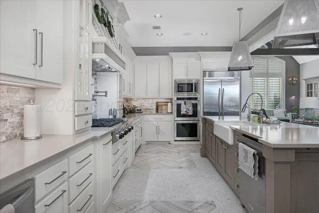 a large kitchen with stainless steel appliances lots of counter space sink and a refrigerator