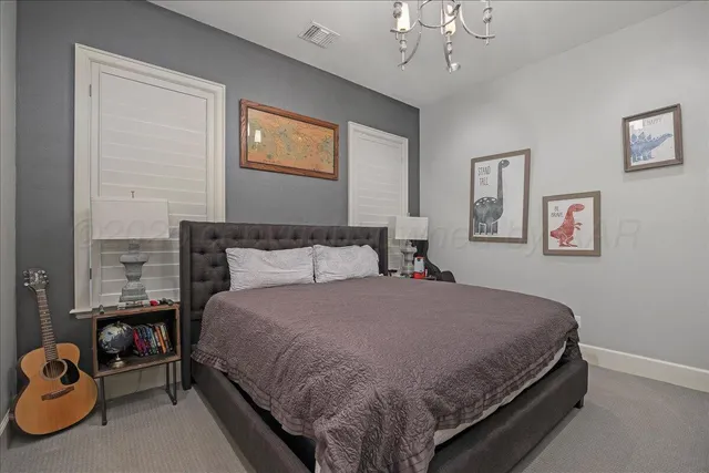 a large bed sitting in a bedroom next to a chandelier