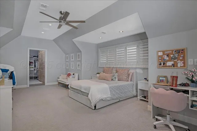 a bedroom with a bed a couch and a chandelier