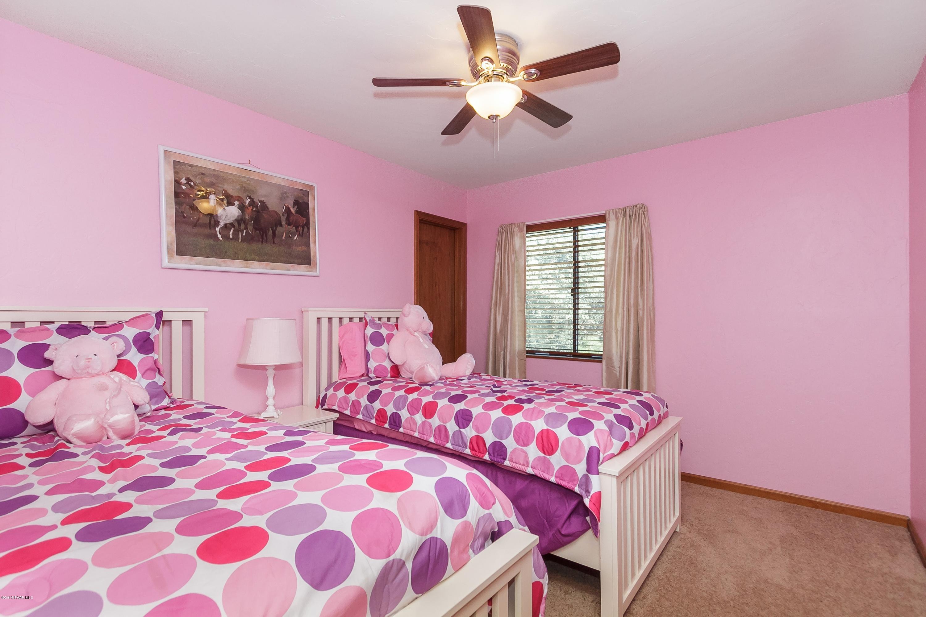 914 Forest Hylands Road Prescott, AZ 86303 - Photo 14 of 22 a bedroom with a bed and a chandelier
