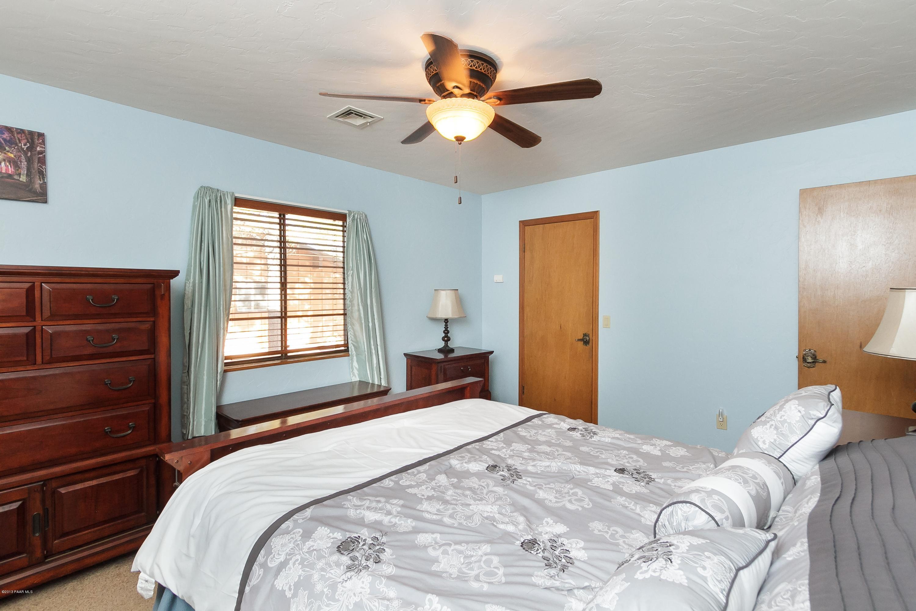914 Forest Hylands Road Prescott, AZ 86303 - Photo 10 of 22 a bedroom with a bed and a chandelier