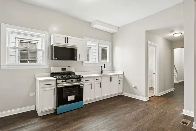 a kitchen with a stove a sink and a microwave